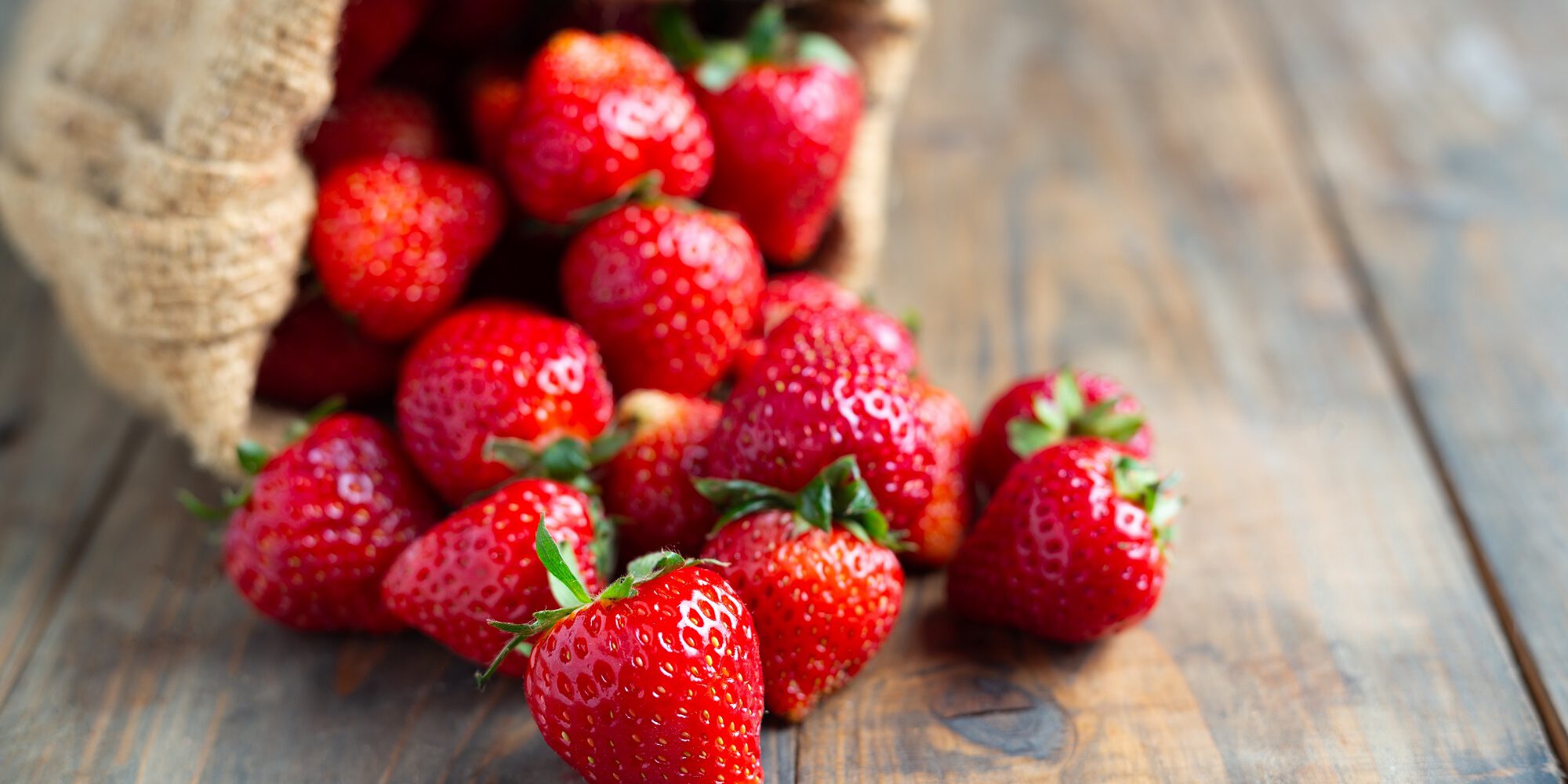 Fresh strawberries on wooden table.